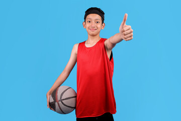 Asian basketball player boy showing approval gesture while holding a ball