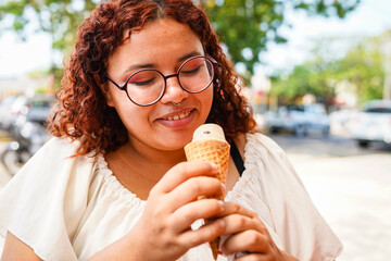 Young Latin woman enjoying ice cream outdoors
