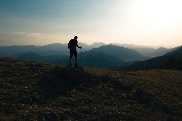 Man climbing to the top of a mountain. Back view of a climber admiring the view of success. Success and adventure.
