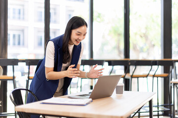 Fototapeta premium asian business woman sit at laptop holding papers, read received contract, agreement, legal documents smile feel satisfied, got good news. Loan repayment, career advance, success concept 