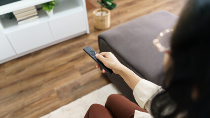 Elderly woman Watching smart TV and using remote controller Hand holding television audio remote control Middle age Asian woman movie Television series spending time at home