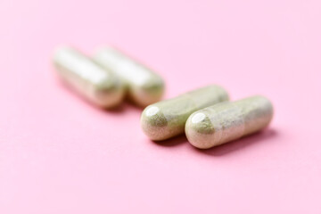 Barley grass capsules. Antioxidants. Concept for a healthy dietary supplementation. Bright background. Soft focus. Close up. Copy space.