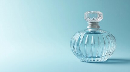 Clear glass perfume bottle on a light blue background