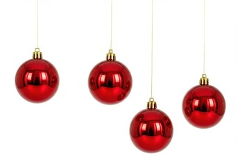 Four shiny red christmas ornaments hanging from gold strings against a white background space for holiday text