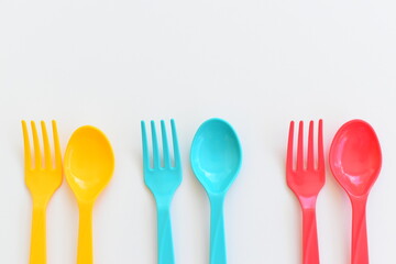 colorful spoon and fork isolated on white background, plastic cutlery for picnic