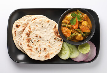 Indian traditional cuisine food mix veg curry made with carrots potatoes cauliflower beans and bell peppers with tandoori roti