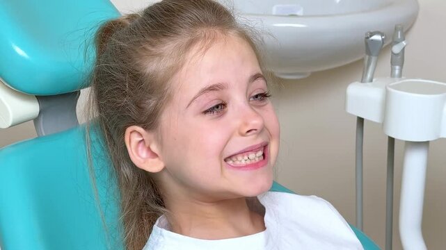 Little girl sitting in dentist chair showing her teeth to doctor. Baby teeth concept. Beautiful smiling preschool girl lost baby tooth. Dental hygiene concept