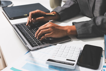 Working from home, Closeup business woman using laptop computer and analyzing financial report.