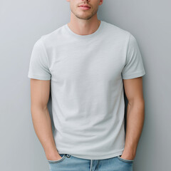Fashion mockup of an attractive male model wearing a flat grey heather-colored round-neck t-shirt, standing in front of a grey wall for a visual illusion. The image was shot from t