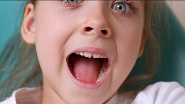 Close up happy funny little girl laughing with her mouth open. Happy childhood. Positive energy. High quality 4K footage
