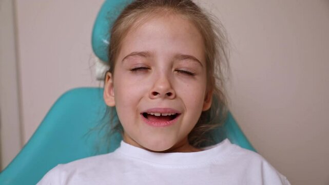 Little girl sitting in chair and sneezing. Suffering from allergy. Slow motion footage