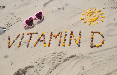 Sunglasses, inscription vitamin D and shape of sun on sand at beach, concept of vacation time
