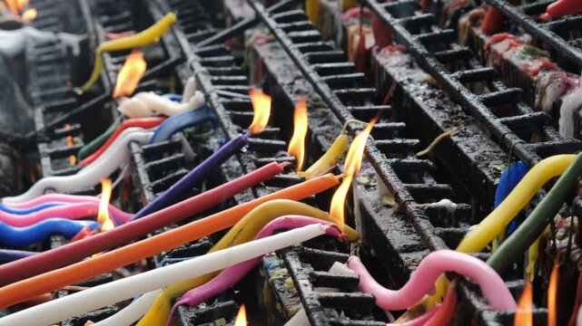 Candles of various colors burn brightly on an altar in a Catholic church in the Philippines, each color representing a unique intention and spiritual meaning
