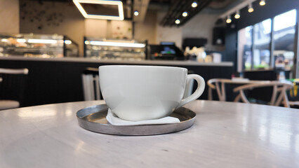 Coffee cup on a table in a modern cafe setting with soft lighting