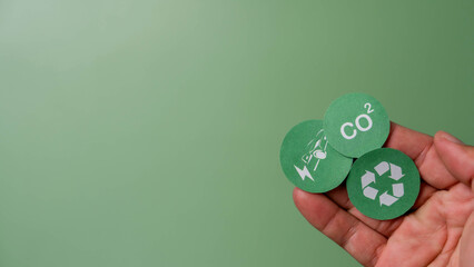 CO2, renewable energy saving and battery for electric car icons placed on hand in top view. Green Energy and Sustainability Concept. sustainability, environmental conservation, Reduce CO2 emission