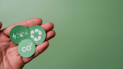 CO2, renewable energy saving and battery for electric car icons placed on hand in top view. Green...