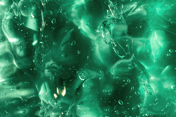 Liquid gel abstract cosmetic in green background. Smear of transparent moisturizing product of aloe