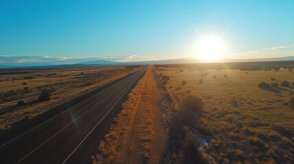 Fototapeta premium Aerial View of an Endless Highway Stretching into the Horizon Under a Golden Sunset, Symbolizing Boundless Opportunities and the Journey of Life