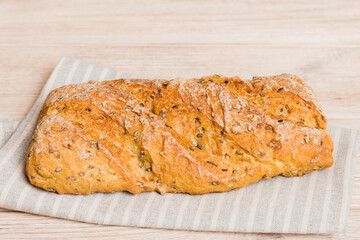 Assortment of freshly baked bread with napkin on rustic table top view. Healthy unleavened bread. French bread