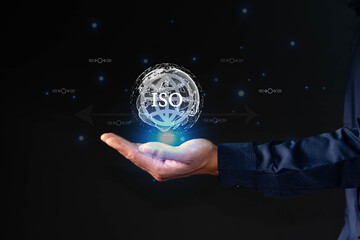 Businessman holding glowing iOS sign with globe icon, representing achieving global ISO standards, strict quality assurance and ISO compliance in digital business.