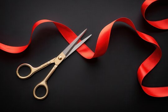 Golden scissors cut a vibrant red ribbon for a grand opening.