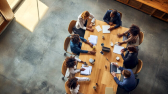 Top view of a blurred team collaborating around a table. office setting filled with motion, brainstorming, and planning energy, symbolizing teamwork, workforce synergy, and modern work culture
