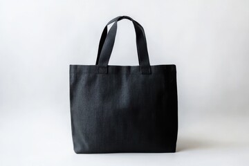 A black canvas tote bag with sturdy handles against a plain white background, perfect for everyday use and sustainable shopping.