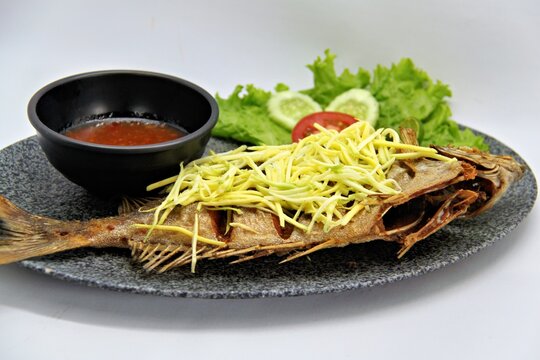 Crispy fried rabbitfish (baronang) topped with spicy and tangy mango sauce. A flavorful Indonesian seafood dish served fresh and vibrant.