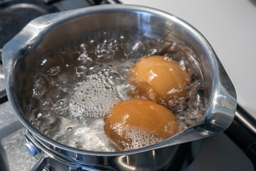 Eggs being boiled in pan of water