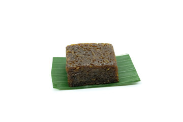 A Homemade traditional cake called wajik ketan gula merah is served on a banana leaf isolated in a...