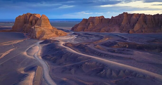 Yardang landform mountain with tire tracks at dusk. Famous Dahaidao no man's land natural landscape in Xinjiang, China.