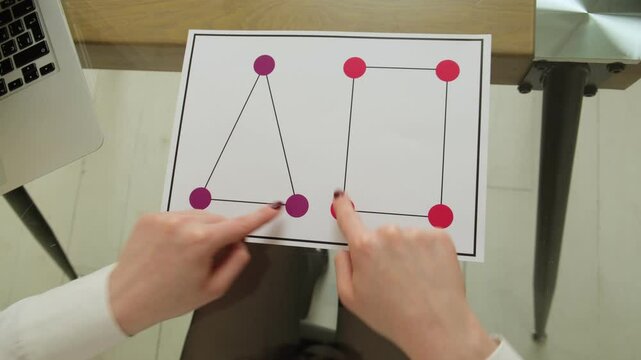 Hands performing brain activation exercise called Triangle and Square using finger coordination over printed shapes to enhance cognitive function and neuroplasticity through neurogymnastics activity