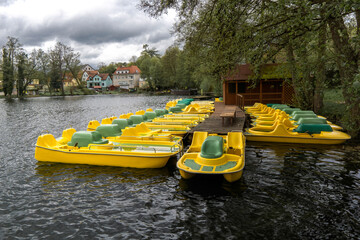 Yellow water bicycles locked at lake marina dock pier.