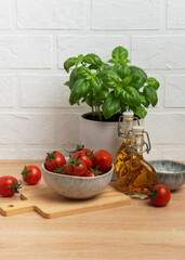 Cherry tomatoes and basil with olive oil on kitchen table
