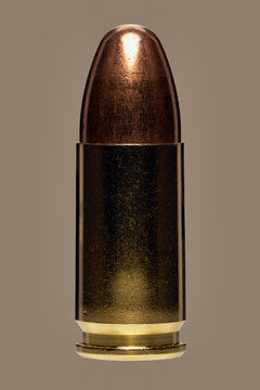Close up studio shot 9 x 19mm bullet on brown background
