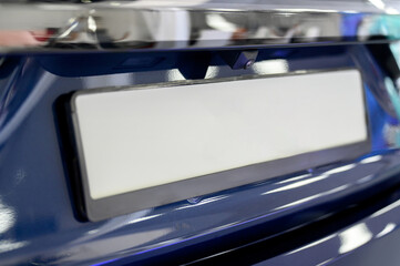 Close-up view of a car's license plate holder with a white background.
