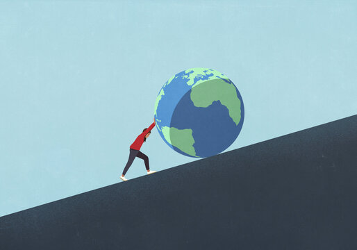 Woman pushing large globe uphill
