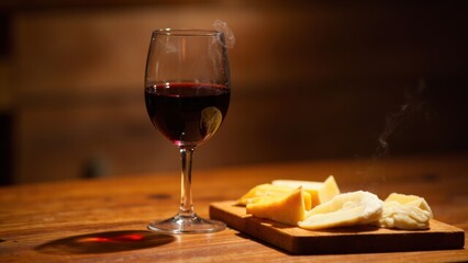 Red wine and cheese on rustic wood table