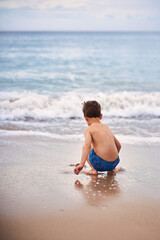 Joyful child enjoying summer vacation by the sea
