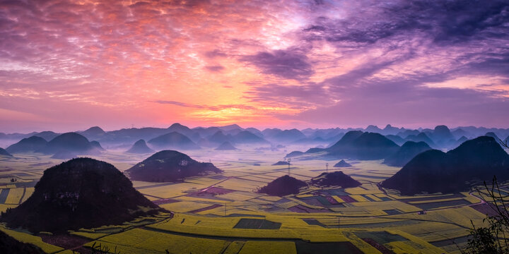 Dramatic pink sunrise over hills and oilseed rape fields, Luoping, Qujing Prefecture, Yunnan Province, China