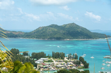 Naklejka premium Tropical aerial view of Baie Sainte Anne on Praslin Island, Seychelles, with green hills