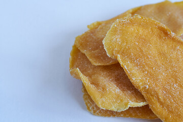Dried mango slices on white background. Close up. Selective focus.