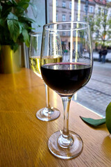Red and White Wine in Glasses on a Wooden Table by a Window for Relaxed Dining