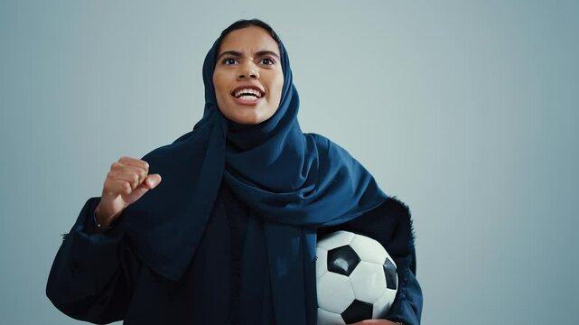 Studio portrait of an attractive young muslim woman wearing a traditional dark blue hijab, posing on a white background. Young football soccer fan supporting uae team. - Powered by Adobe