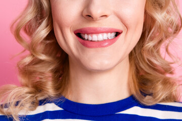 Close up portrait of a young woman with a cheerful smile and curly blonde hair, styled in a casual...