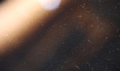 grainy colorful warm orange light leaks on black background with dust texture. abstract damaged scratched retro film analog effect for using over photos as overlay or screen filter