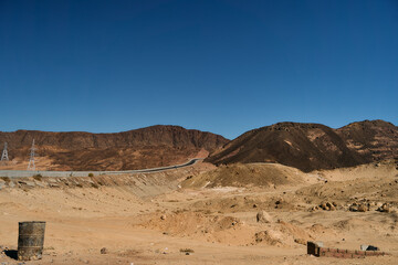 A vast and expansive desert landscape characterized by rugged mountains under a brilliantly clear...