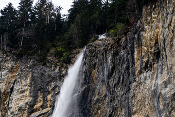 Crystal-clear waterfall flowing over rocks – scenic nature landscape