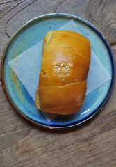 Salty bread in blue dish on wooden table top view