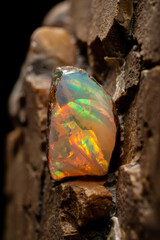 Stunning Close-Up of Iridescent Opal Gemstone Embedded in Rocky Background with Warm Earth Tones